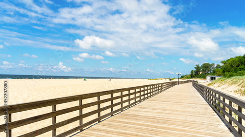 Long wooden promenade along the sandy beach of the Baltic Sea in the village of Yantarny  Kaliningrad region  Russia