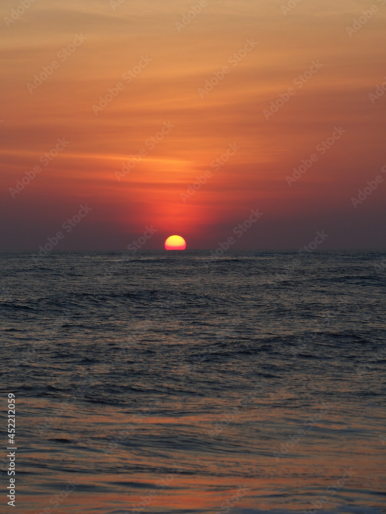 Red sunset with small waves in the foreground