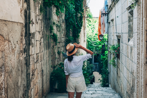 Canvas Print Girl tourist walking through ancient narrow streets on a beautiful summer day in