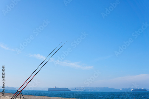 Two fishing rods on the Brixham seaside. Rod rings. Fishing tackle. Fishing spinning reel.