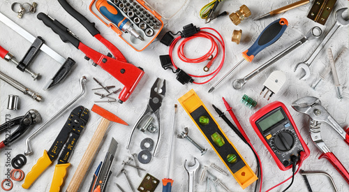 Set of hand tools on white plaster background. Work tools for electrician, carpenter, mechanic, plumber and hobist. Top view, flat lay.