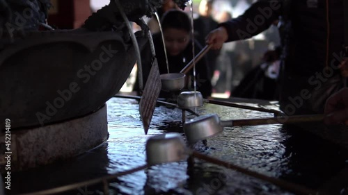 People drinking Holy water at Senso-ji japanese Temple asakusa district Tokyo japan. photo