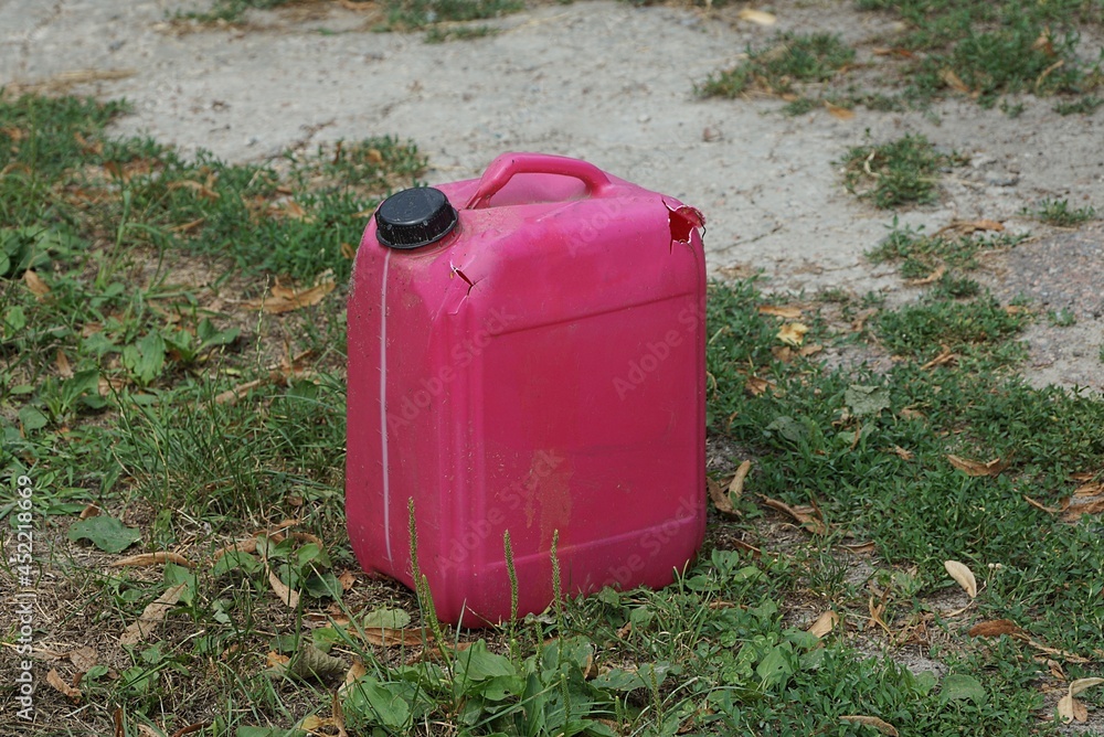garbage from one red plastic canister outdoors in green grass garbage from one red plastic canister outdoors in green grass