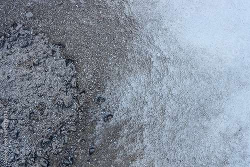 gray white texture of ash with sand and white snow outside