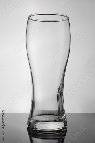 Empty glass beer goblet on a white background. Minimalism. There are no people in the photo. Close-up. Abstraction. Dishes for beer, juice. cocktails.