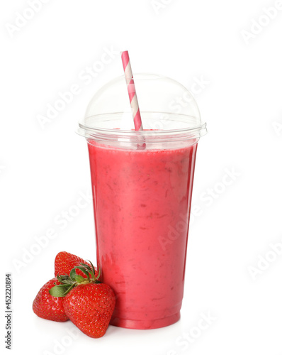 Delicious smoothie with straw in plastic cup and fresh strawberries on white background