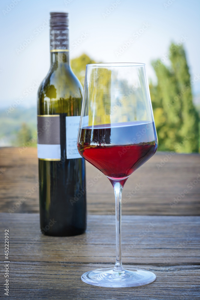Glass of red wine on a street table on a blurred background Glass of red wine on a street table on a blurred background