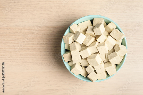 Delicious tofu on wooden table, top view. Space for text