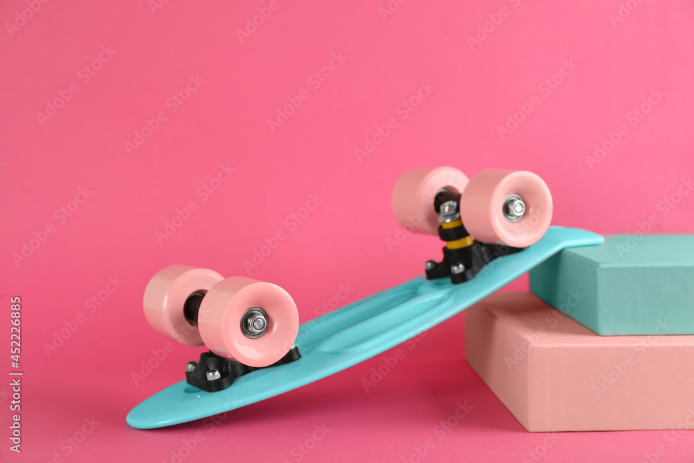 Turquoise skateboard on pink background. Sport equipment Turquoise skateboard on pink background. Sport equipment