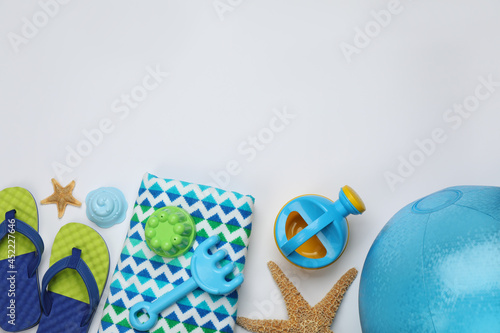 Flat lay composition with beach ball and sand toys on white background