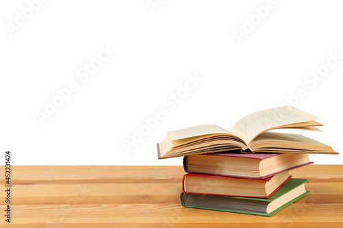 Stack of books on wooden table against white background. Library material