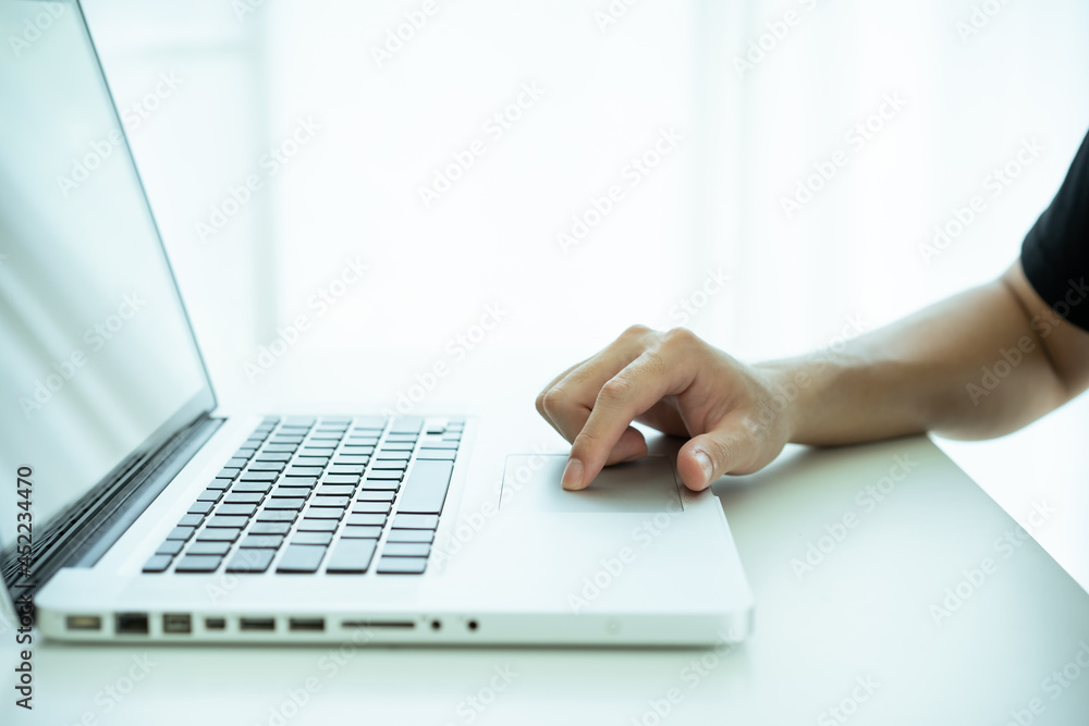 Unrecognizable Asian young man working and typing on the laptop computer keyboard. Unrecognizable Asian young man working and typing on the laptop computer keyboard.