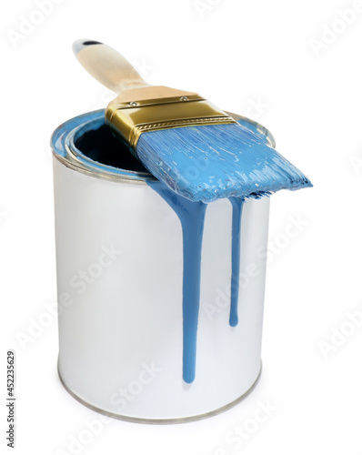 Can of blue paint with brush on white background