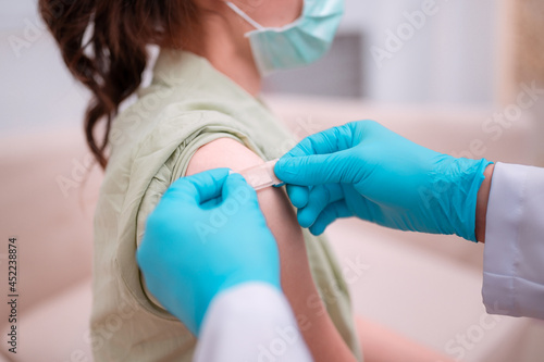 Close up doctor holding syringe and using cotton before make injection to patient in medical mask. Covid-19 or coronavirus vaccine