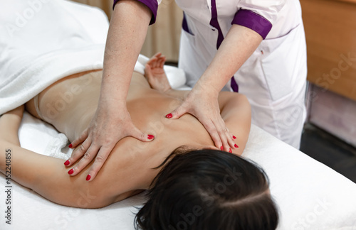 Close up of woman masseur hands during back massage.