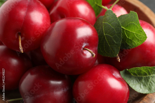 Delicious ripe cherry plums with leaves, closeup