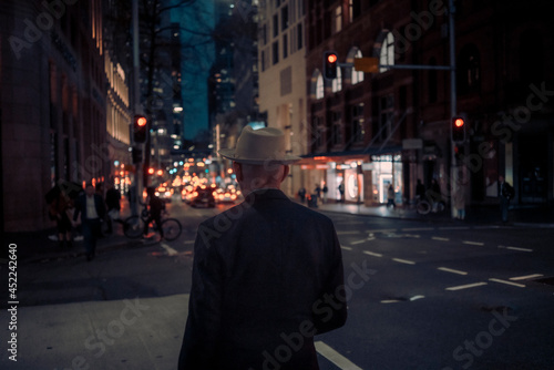 Man on the street corner in a night city street scene
