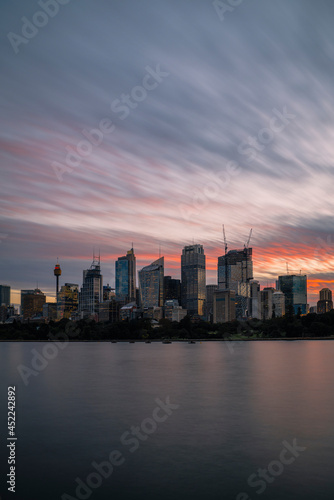 Sunset illuminating the wispy clouds in the sky above the Sydney city skyline © Southern Creative