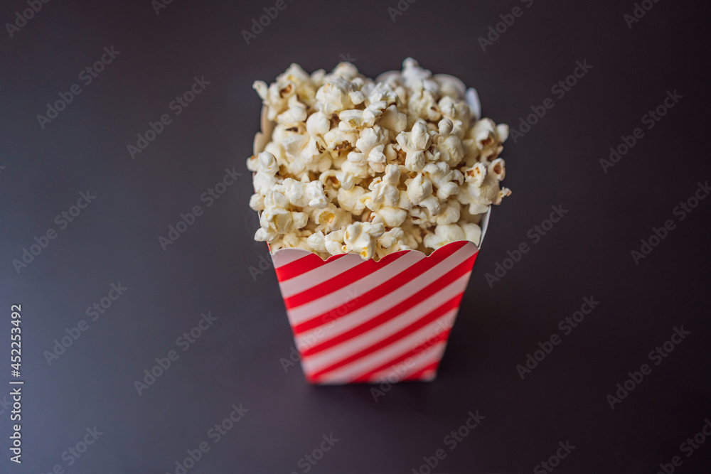 Popcorn in red and white container on a dark background