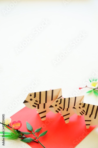 Fototapeta Naklejka Na Ścianę i Meble -  年賀状に使える松竹梅飾りと折り紙のホワイトタイガー3頭縦構図
