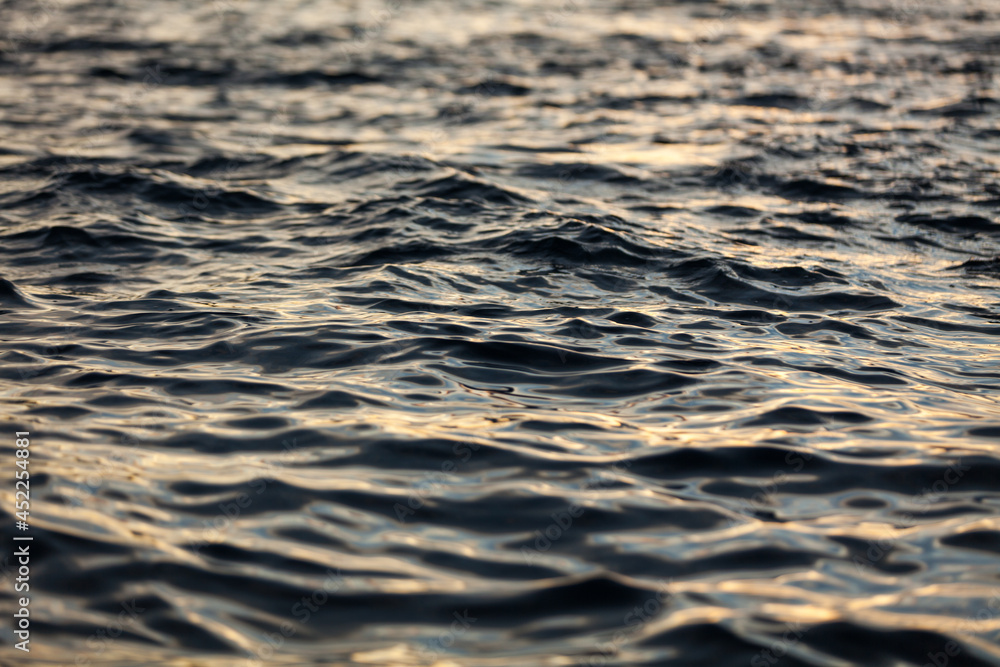 Naklejka premium Surface of the sea water in sunset light