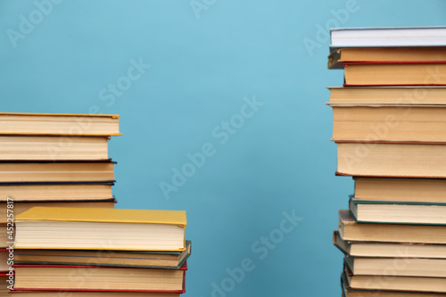 Many hardcover books on turquoise background, space for text. Library material photo