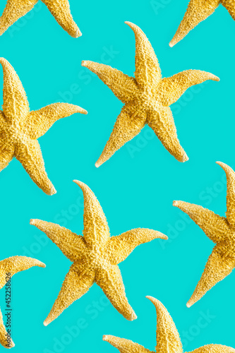 Bright summer pattern with sea stars. Yellow starfish on turquoise, sea summer vacation concept.