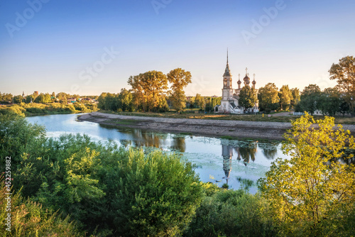 Sretenskaya church on the river bank and reflection in the river in Vologda on an early summer morning