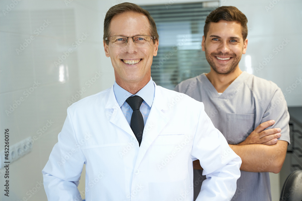 Two colleagues in dental clinic posing for camera Two colleagues in dental clinic posing for camera