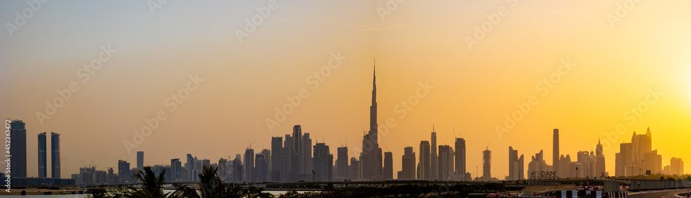 Dubai city skyline at night with a colorful sky and reflection on the water. A view from Al Jaddaf, Dubai, UAE.