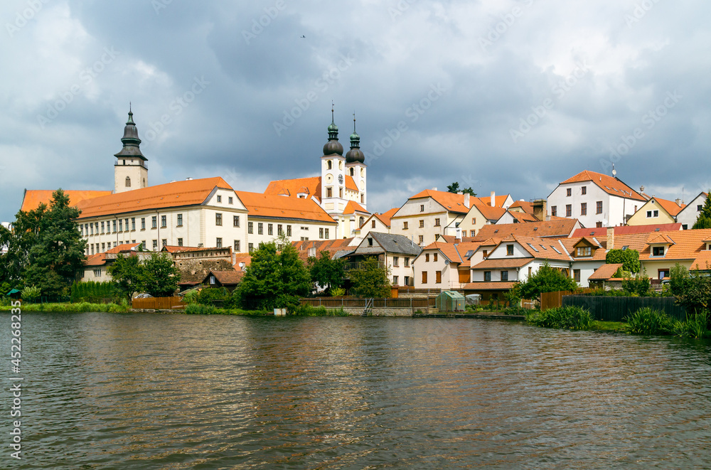 View of Telc city Panorama with cloudy sky seen from the surrounding river. The historic center of Telc in southern Moravia, Czech Republic, is a UNESCO World Heritage Site.