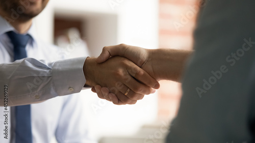 Close up view two businessmen shaking hands after successful formal negotiations. Male HR manager handshake hire candidate at job interview. Mutual respect, business etiquette, make agreement concept