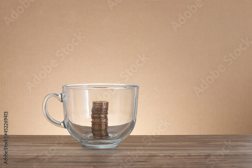 Coins stacked in the transparent glass cup