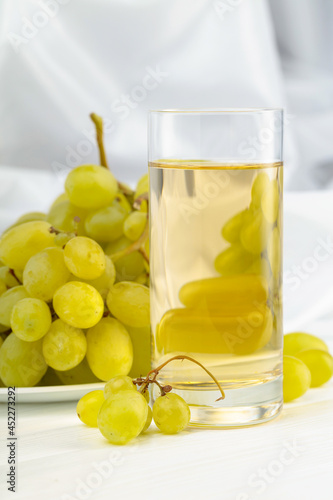 Glass of grape juice and grape cluster.