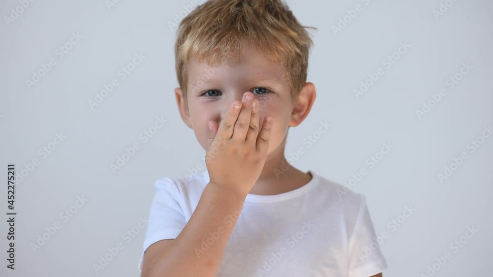 Little boy 5-6 years old in a white t-shirt sends an air kiss Little boy 5-6 years old in a white t-shirt sends an air kiss