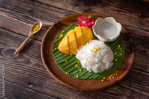 Traditional famous Thai dessert, sweet sticky rice and fresh mango as serve with coconut milk photo