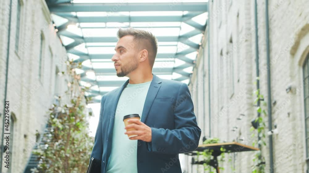 A young successful businessman is standing on the street. Man in a casual wear. Business, freelance and remote work. A young successful businessman is standing on the street. Man in a casual wear. Business, freelance and remote work.