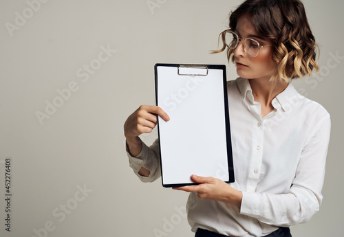 woman in white shirt documents folder in hand professional work