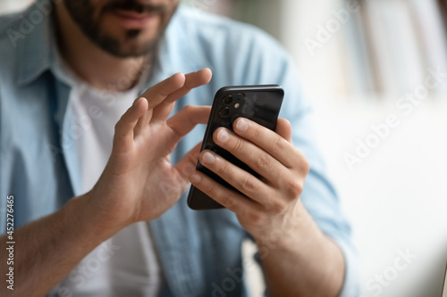 Close up view male hands holds smart phone spend time online use mobile application. Client of e-commerce shopping, electronic service buyer, chat on-line. Solve business remotely, modern tech concept
