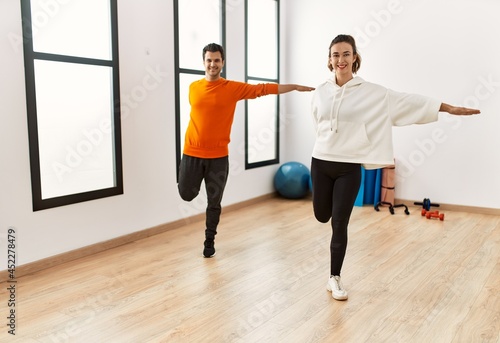 Young hispanic sporty couple smiling happy training at sport center.
