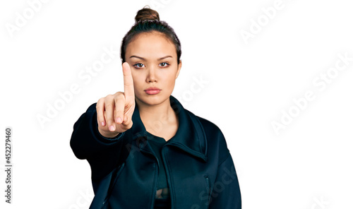 Young hispanic girl wearing sportswear pointing with finger up and angry expression, showing no gesture © Krakenimages.com