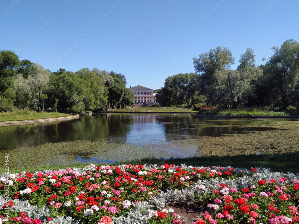 Fototapeta premium View of the Yusupov Palace, Trees, pond and flower beds in the Yusupov Garden in the old center of St. Petersburg. Architecture and recreation places for citizens of the city of St. Petersburg. 