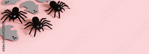 Halloween card with black spiders and grey ghost on pink background © Denira