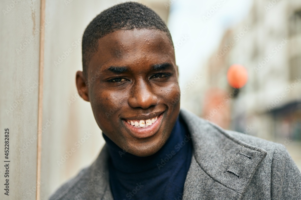 Fototapeta premium Young african american man smiling happy standing at the city