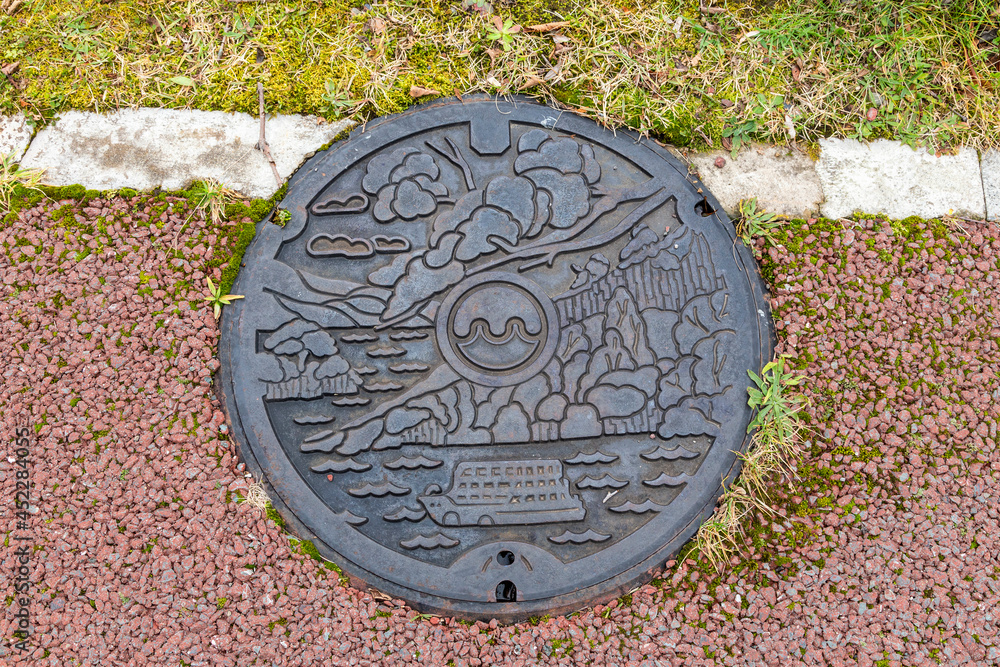 Beautiful graphic manhole cover on the floor near Lake Towada.