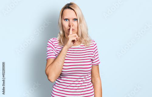 Young caucasian woman wearing casual clothes asking to be quiet with finger on lips. silence and secret concept.