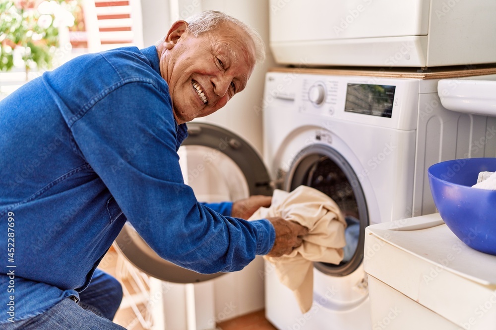 Senior caucasian man smiling happy doing laundry at the terrace. Senior caucasian man smiling happy doing laundry at the terrace.
