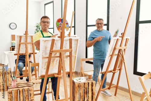 Group of middle age people artist at art studio smiling happy pointing with hand and finger