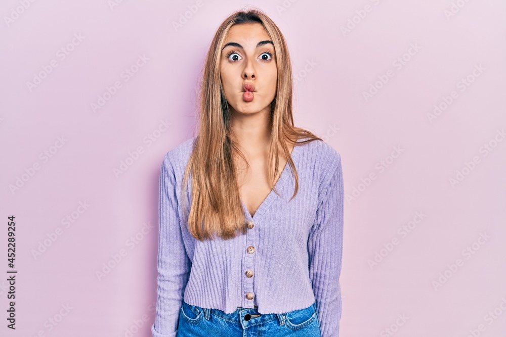Beautiful hispanic woman wearing casual shirt making fish face with lips, crazy and comical gesture. funny expression. Beautiful hispanic woman wearing casual shirt making fish face with lips, crazy and comical gesture. funny expression.