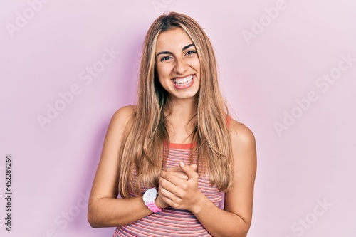 Beautiful hispanic woman wearing casual summer t shirt with hands together and crossed fingers smiling relaxed and cheerful. success and optimistic